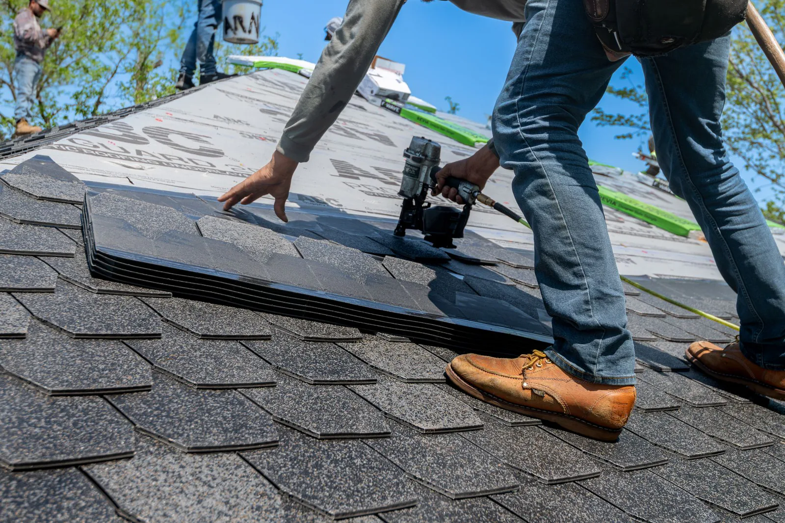 Summit roofer securing new shingles on a completed storm-damage repair